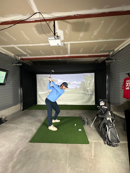 Person using a golf simulator in a home garage setting