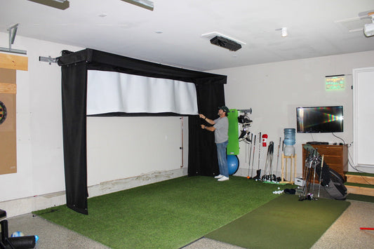Man rolling up Vanish lite semi-retractable golf sim enclosure