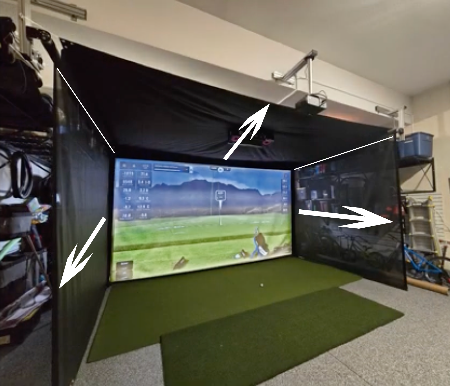 Indoor golf simulator setup in a garage with a screen displaying a golf course.