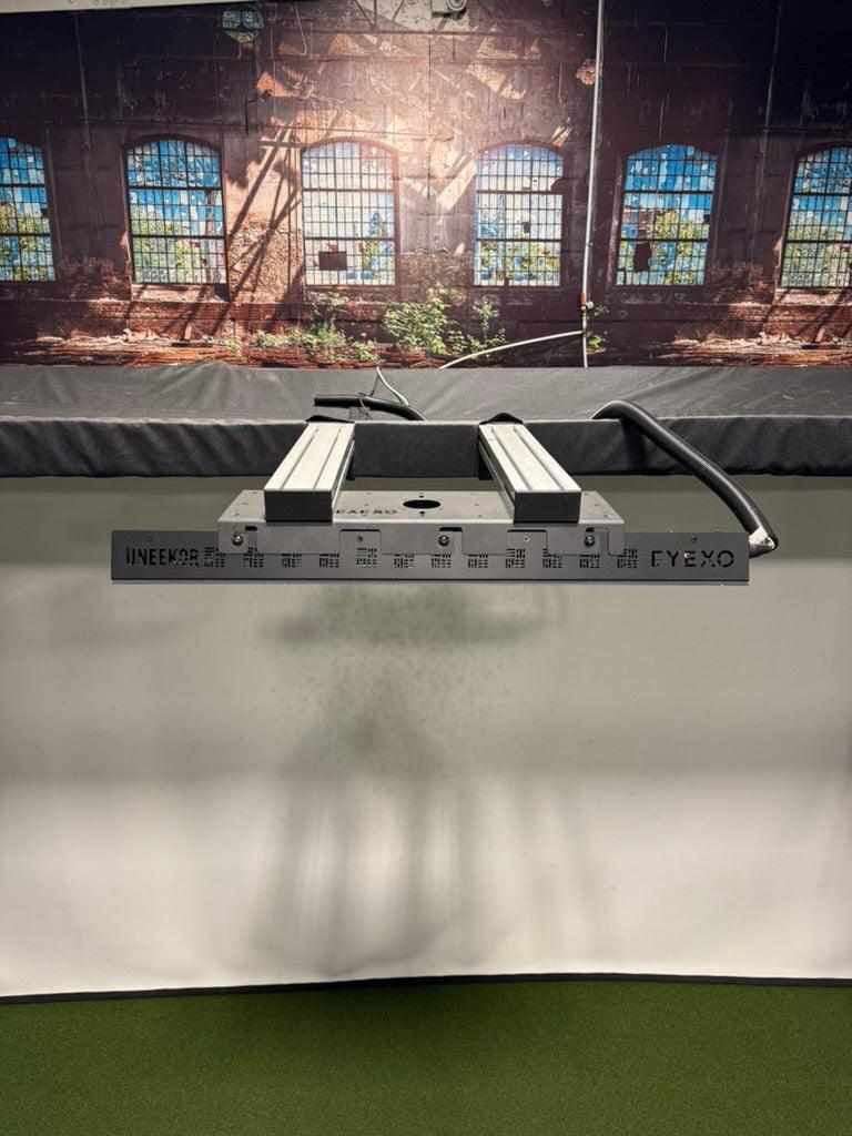 A launch monitor bracket securely mounted to the frame of a golf studio, providing a stable and space-saving setup for accurate swing analysis.