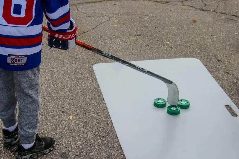 Kid stick handling SportScreen Green Biscuit Pucks on shooting pad
