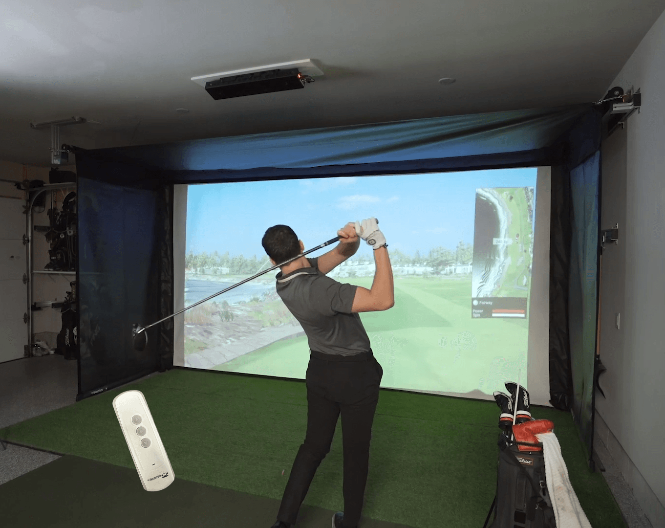 The Vanish Series retractable golf impact screen – a high-end, versatile garage golf studio enclosure with a sleek, roll-up design that easily transforms your space from a professional screen golf setup to an open area.