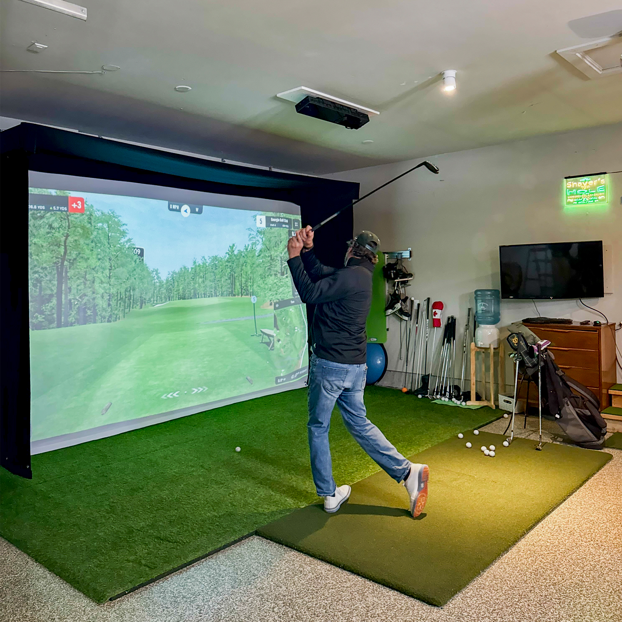 Golfer swinging into the Vanish Lite 13 golf impact screen system